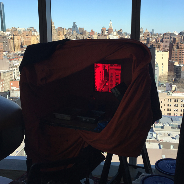 A portable darkroom is silhouetted against the manhattan skyline